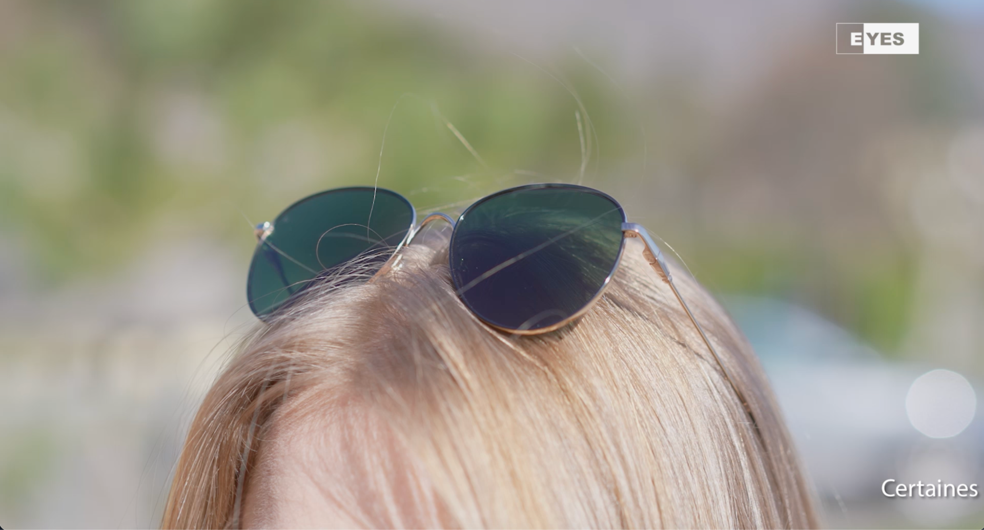 lunettes de soleil rondes monture dorée sur cheveux blonds