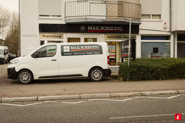 ladenfront von mail boxes etc. mit lieferwagen