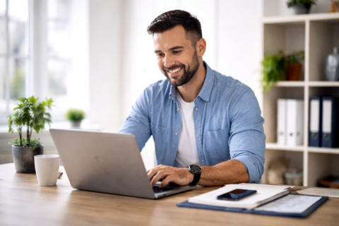 lächelnder mann im homeoffice am laptop