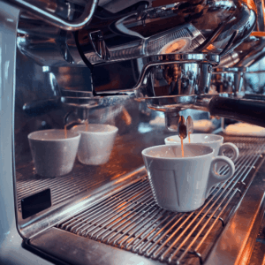 espresso profesional vertiendo café con crema en tazas blancas