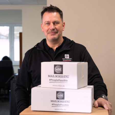 mbe mitarbeiter im paketshop bereitet sendungen vor