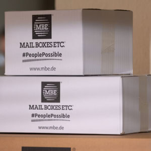 gestapelte mbe versandkartons mit markenlogo