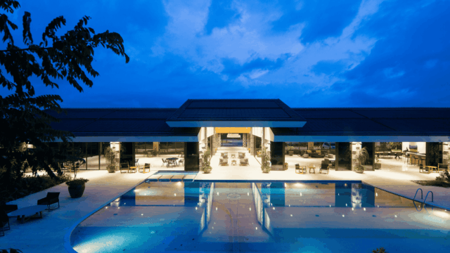 modern pool pavilion at twilight with glass facade