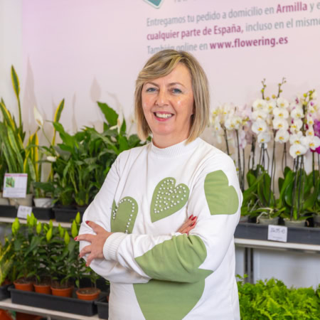 mujer sonriente en tienda de plantas y orquídeas
