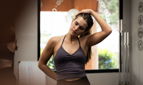 mujer estirándose en estudio de fitness