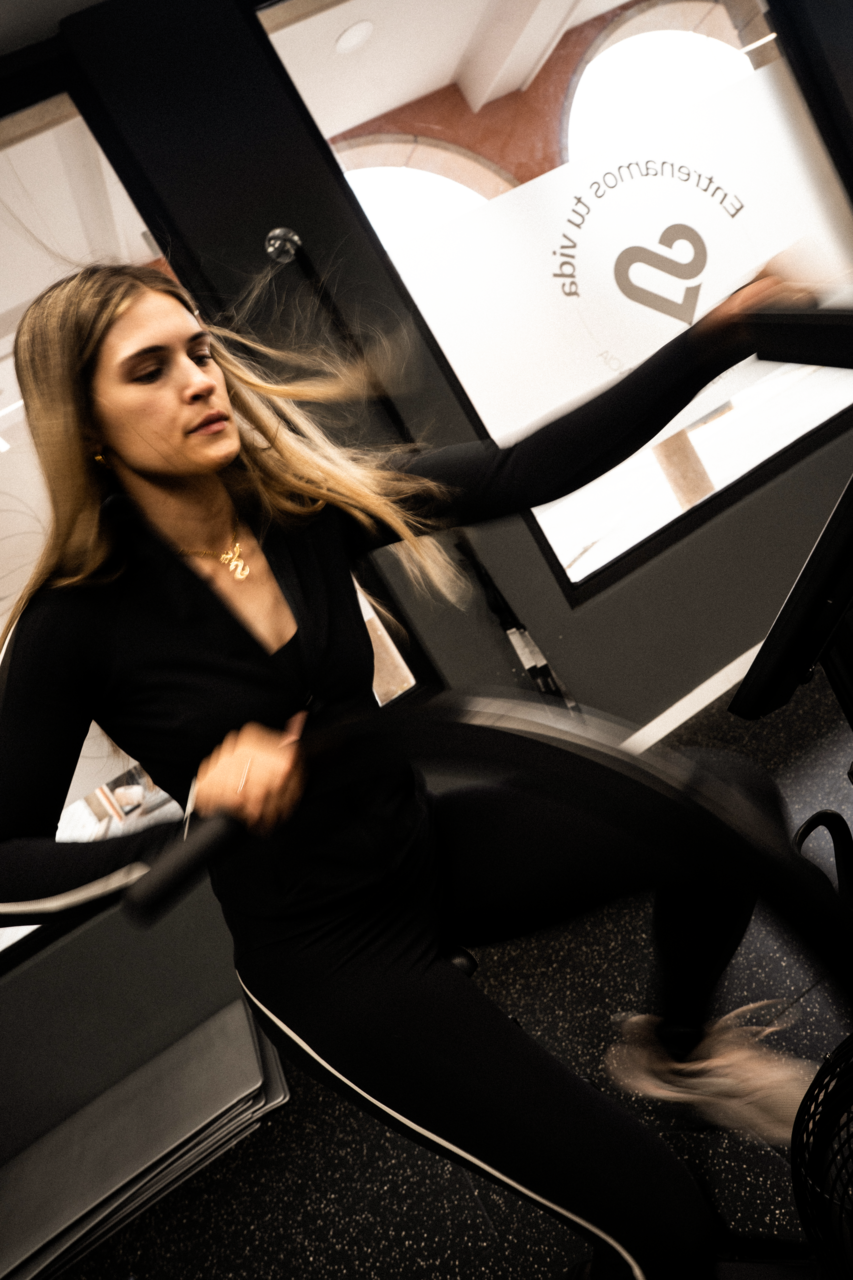 mujer en bicicleta estática en gimnasio moderno