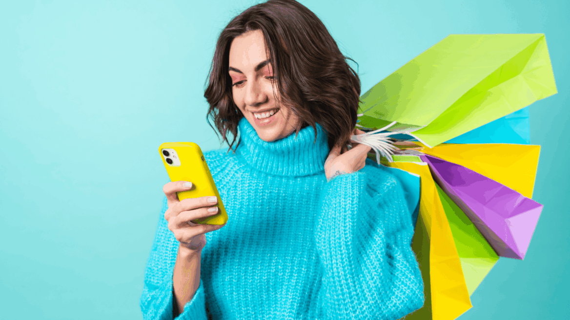 mujer sonriente con teléfono amarillo y compras