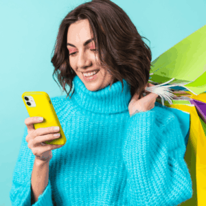 mujer sonriente con teléfono amarillo y compras
