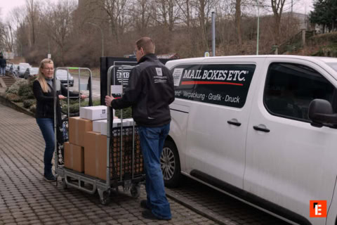 paketzusteller beim beladen des lieferwagens