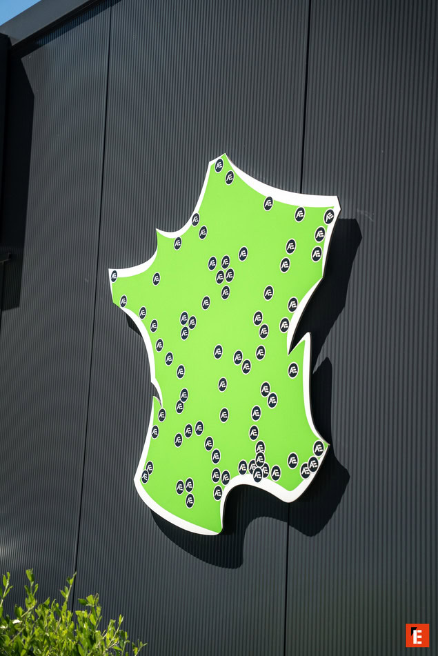 panneau vert néon en forme de carte sur mur métallique