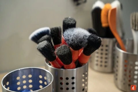 pinceaux de maquillage orange dans pot métallique perforé