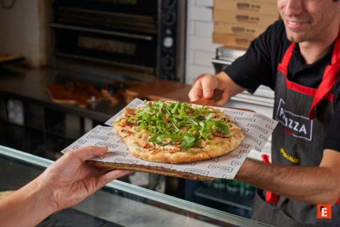 pizza recién horneada con rúcula entregada a mano