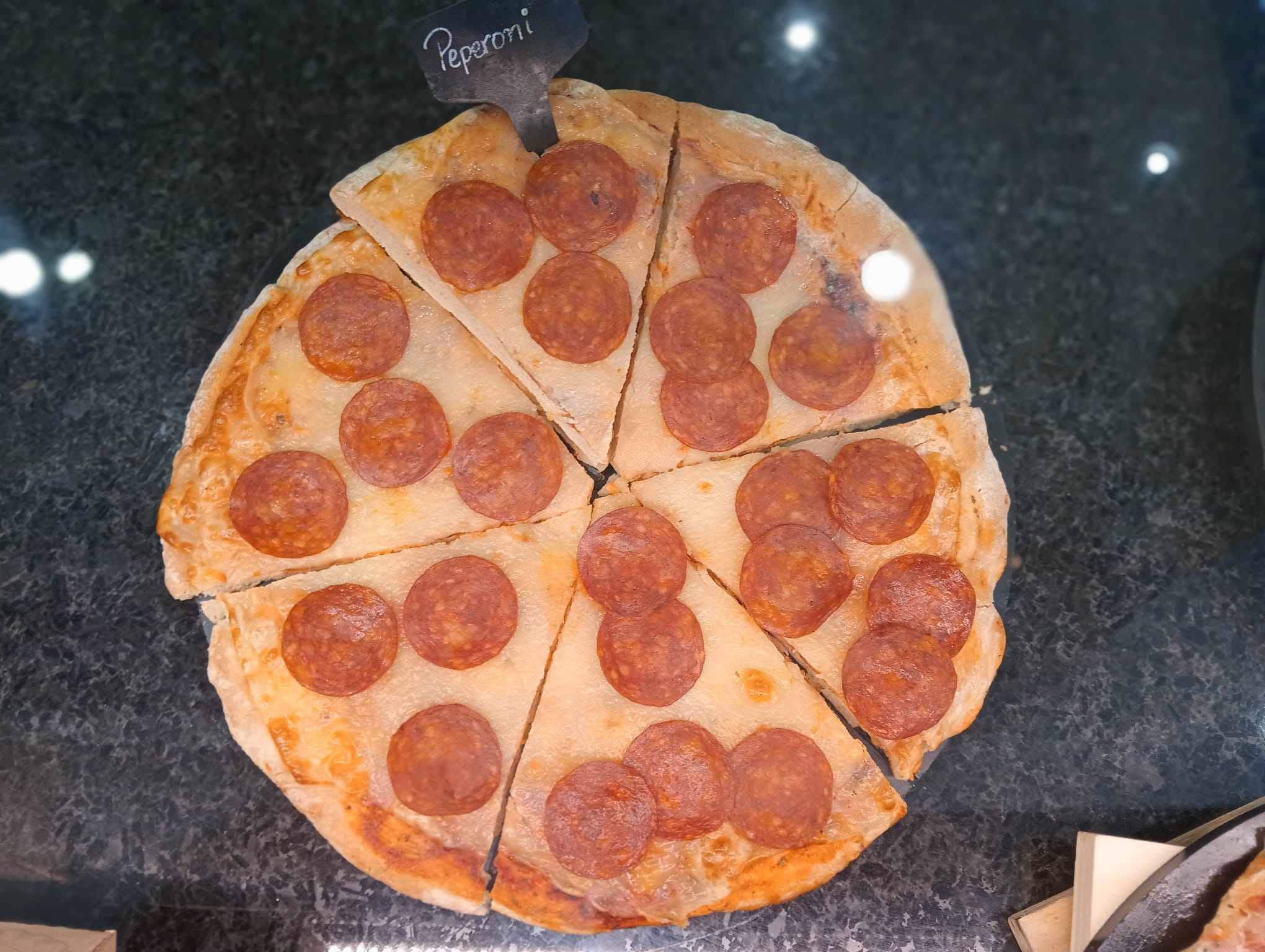 pizza de pepperoni vista cenital en mostrador oscuro