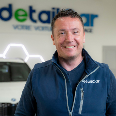 employé souriant en atelier de détailing auto