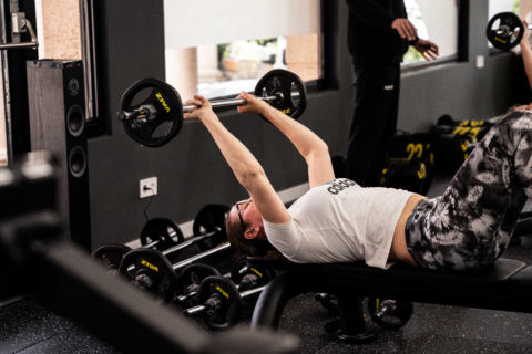 mujer haciendo press de banca en gimnasio