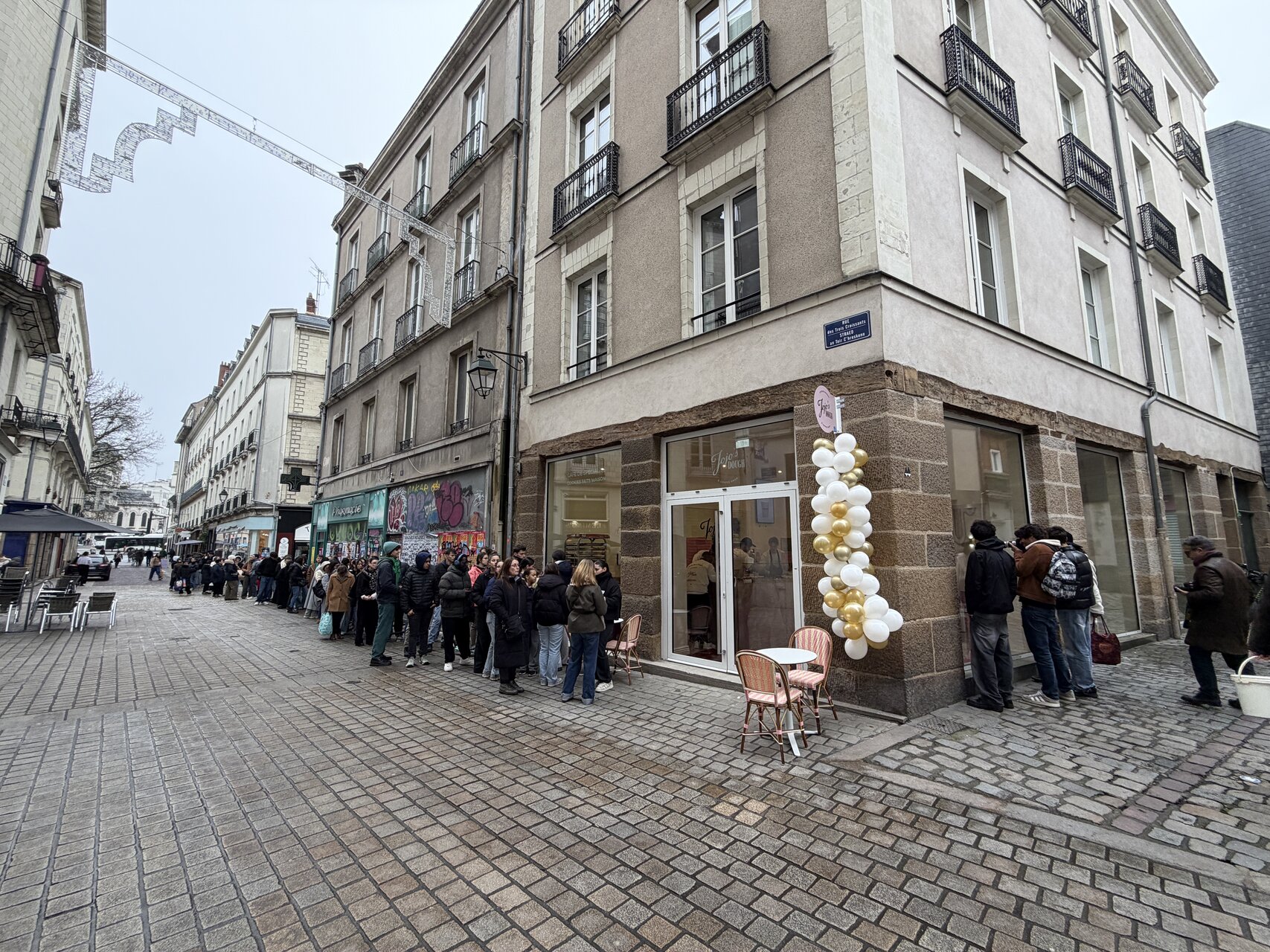 file dattente devant boutique décorée de ballons
