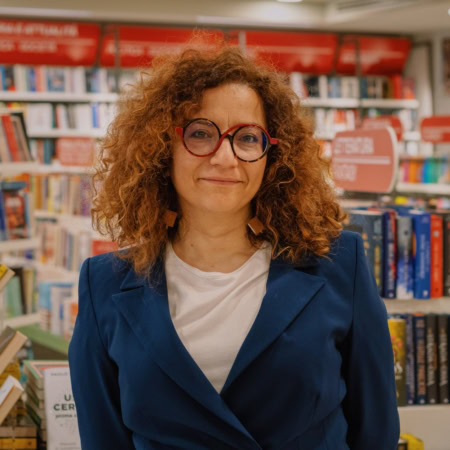 ritratto in libreria: donna con occhiali rossi