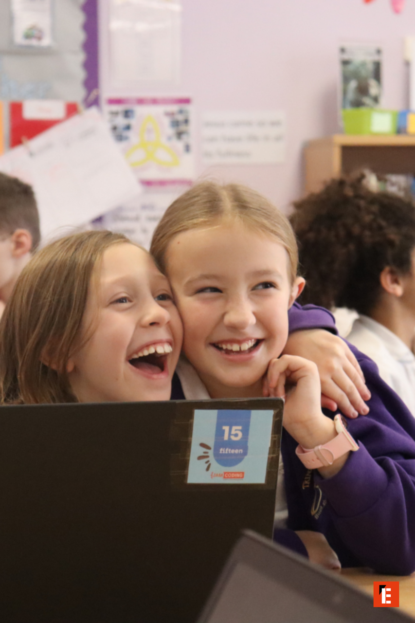 students laughing over classroom coding project
