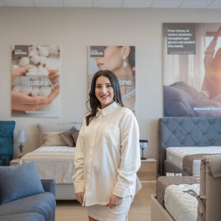 consulente sorridente in showroom di letti e divani