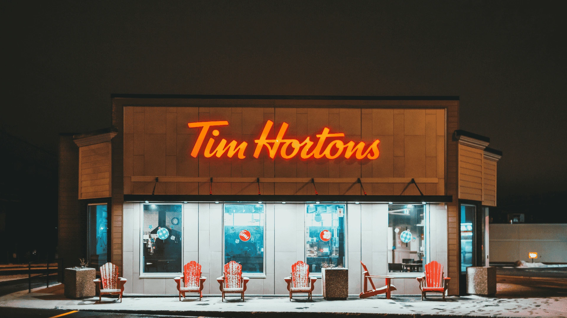 tim hortons at night: neon sign and snowy red chairs