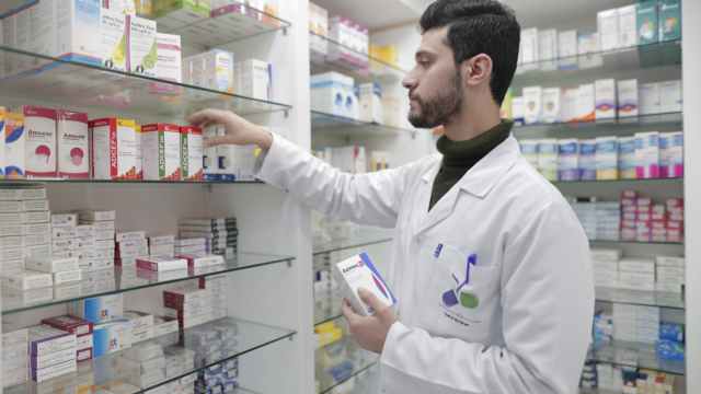 apotheker wählt medikamente im modernen regal