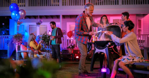 evening backyard grill party under colorful lights