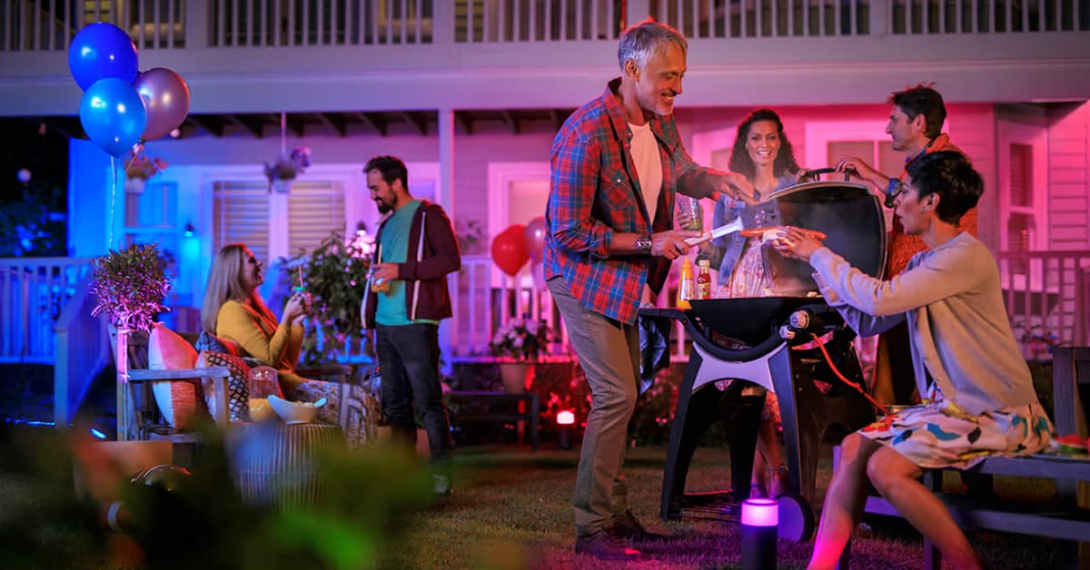 evening backyard grill party under colorful lights
