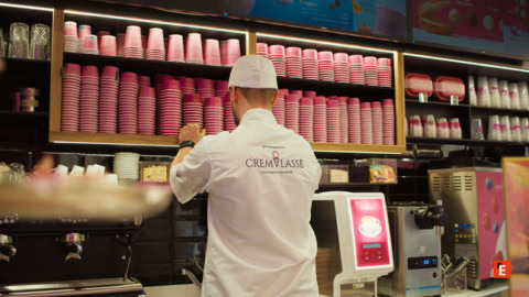 barista al banco con bicchieri rosa e macchina espresso