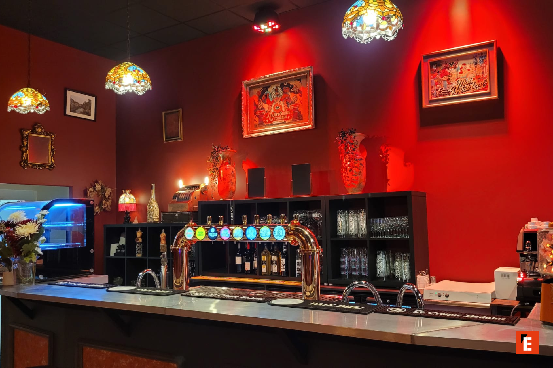 comptoir de bar rétro, mur rouge et tireuses chromées