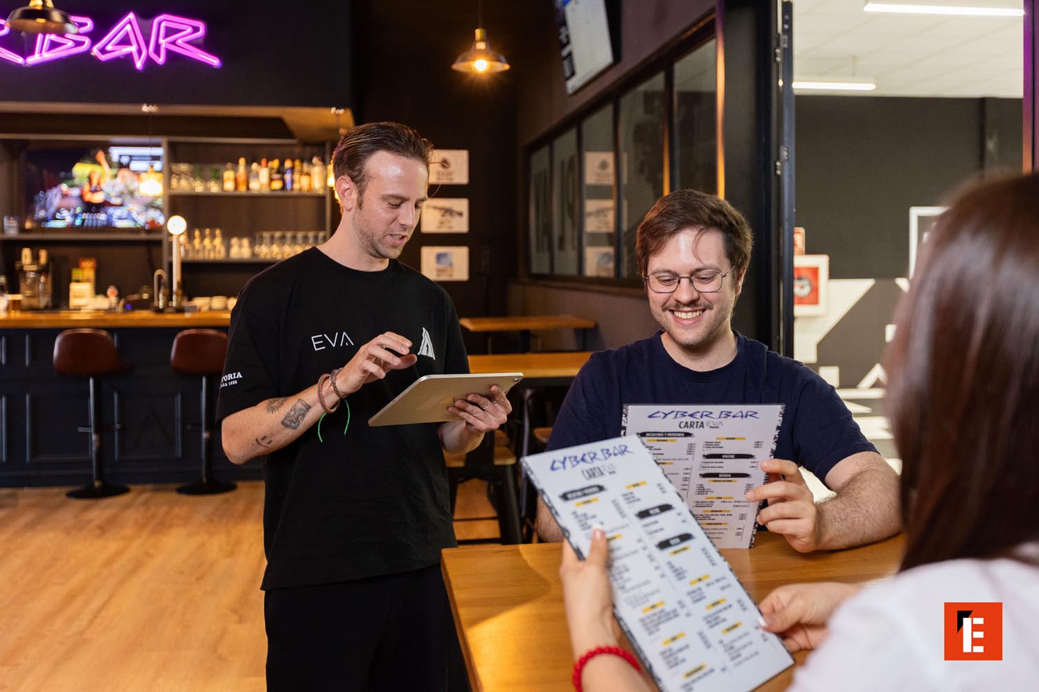 bar moderno con neón: camarero y tablet