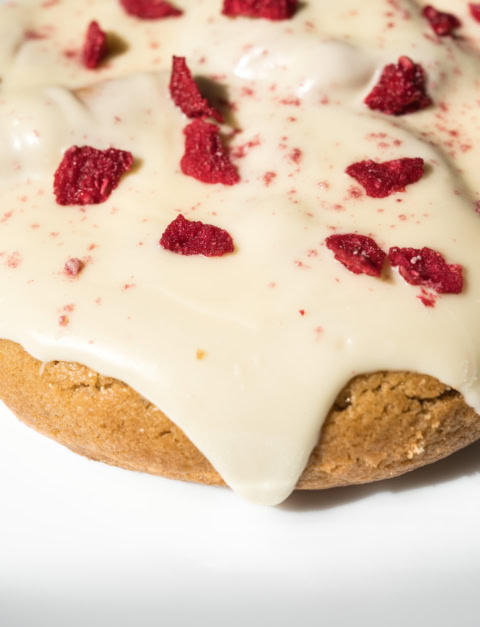 gros plan biscuit au glaçage vanille et framboise lyophilisée