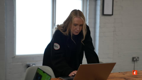 blonde woman working on laptop in bright office