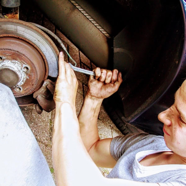 mechaniker repariert verrostete bremsscheibe am auto