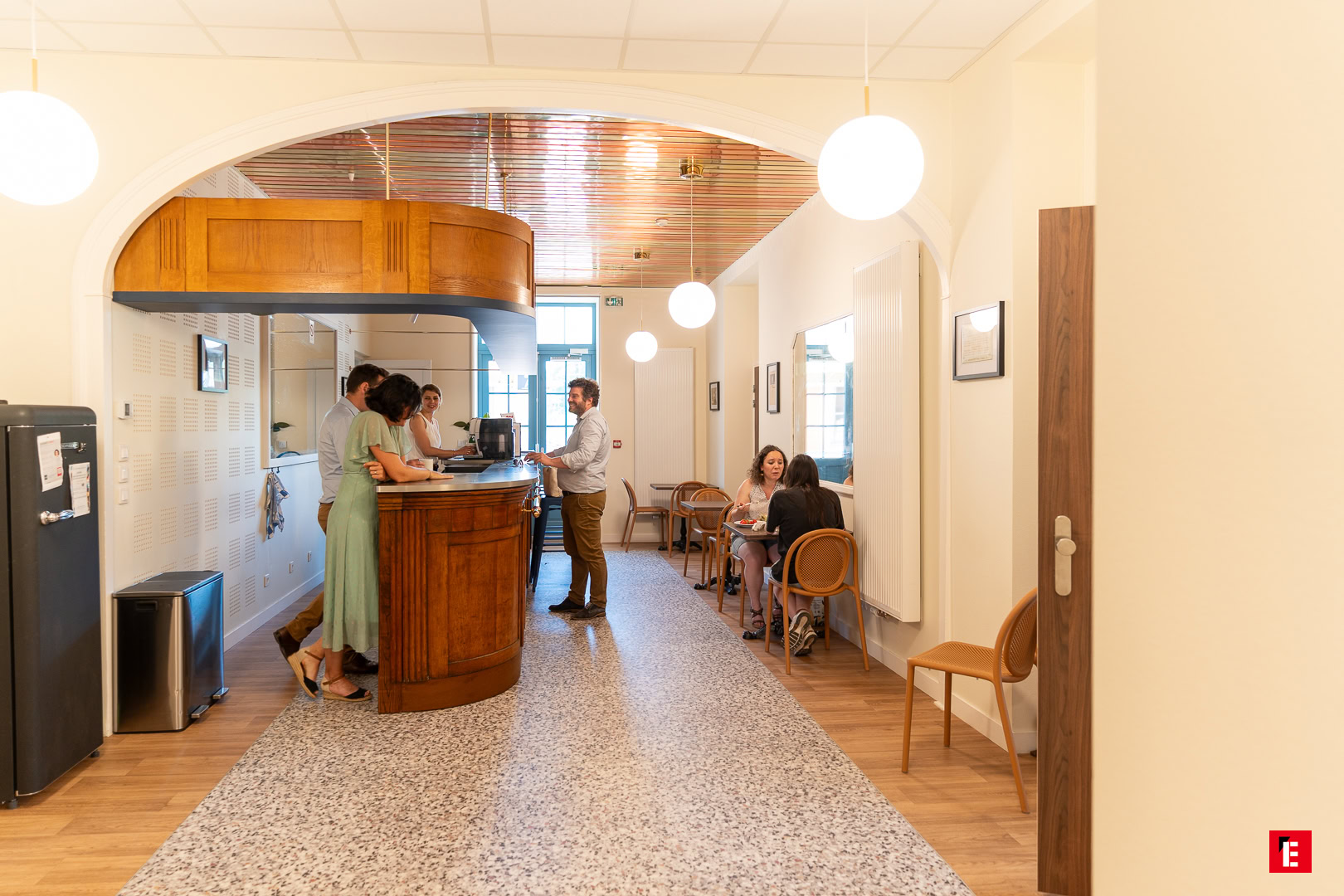 café chaleureux au comptoir en bois et allée terrazzo