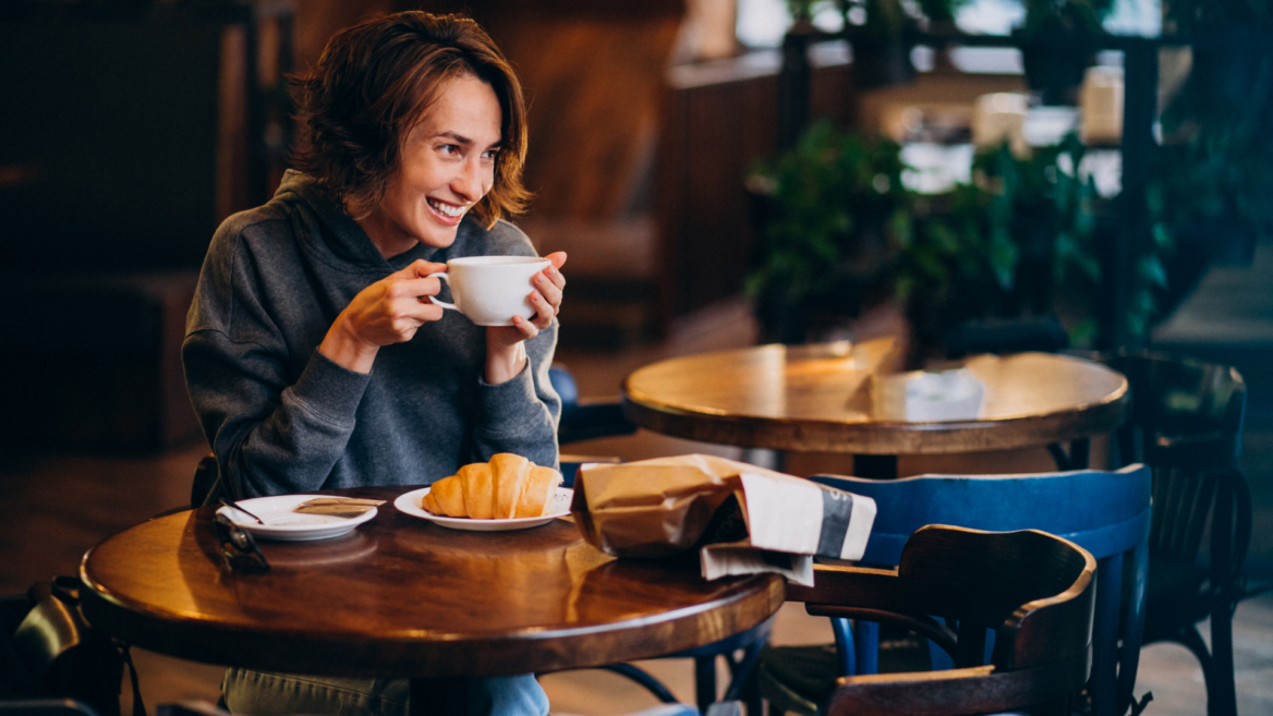 lächelnder moment im café mit croissant