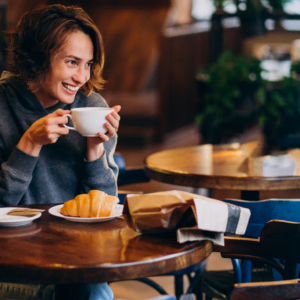 lächelnder moment im café mit croissant