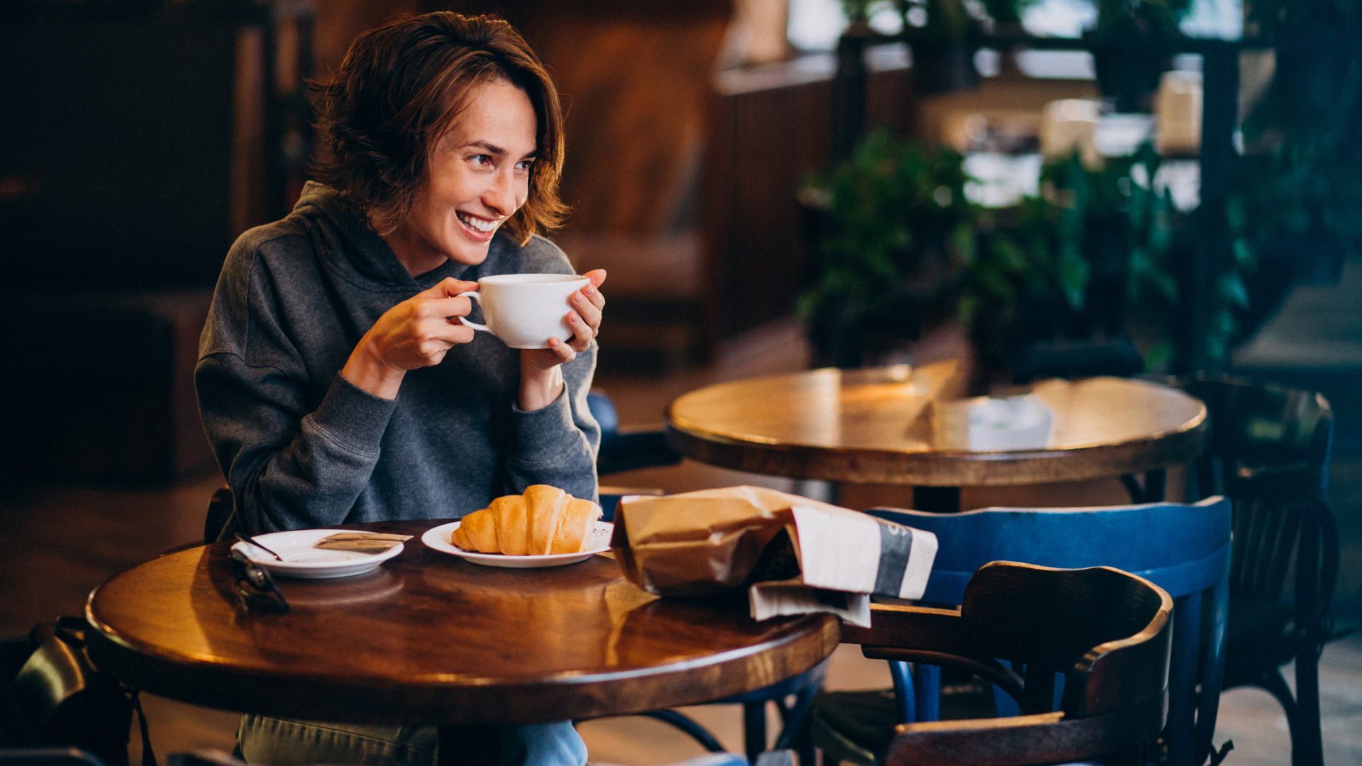lächelnder moment im café mit croissant
