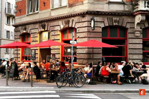 terrasse de café animée aux parasols rouges