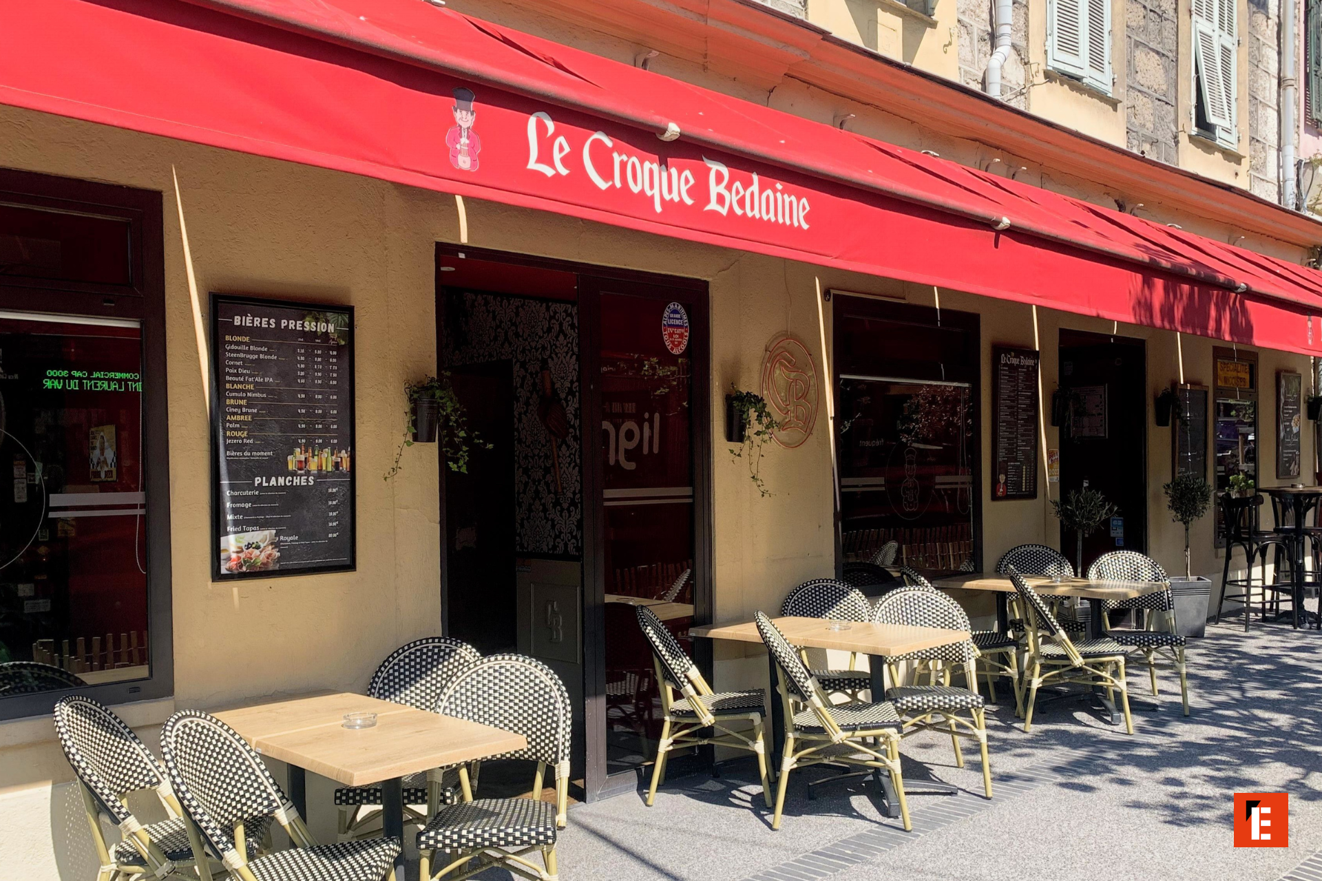 terrasse de café parisien auvent rouge au soleil