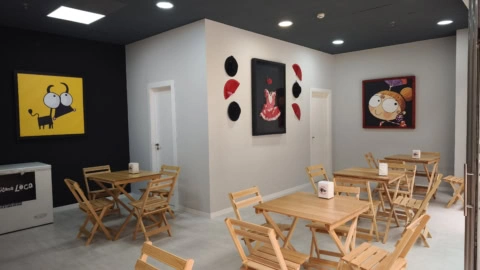 cafetería minimalista con arte y mesas plegables