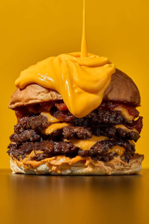 close up stacked cheeseburger with molten cheese