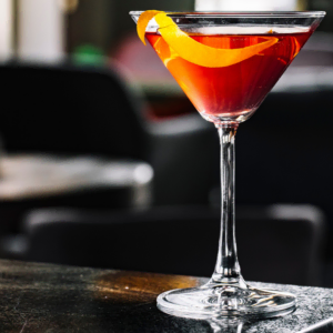 cóctel Ámbar en copa vintage con twist de naranja