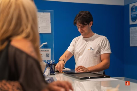 homme au comptoir de service, chemise blanche, bureau bleu