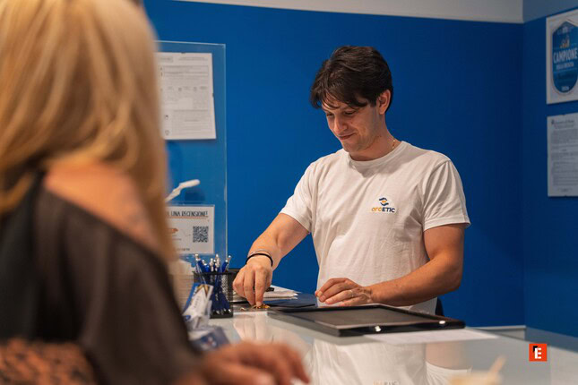 homme au comptoir de service, chemise blanche, bureau bleu
