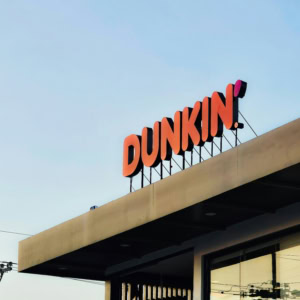 dunkin sur le toit : enseigne orange et ciel bleu