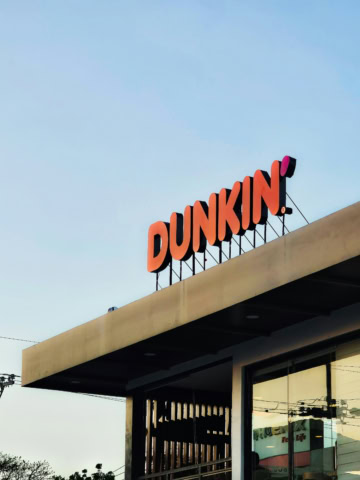 dunkin sur le toit : enseigne orange et ciel bleu