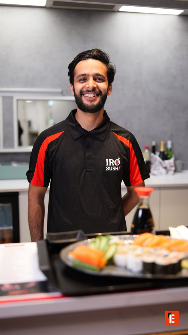 empleado sonriente en sushi bar moderno