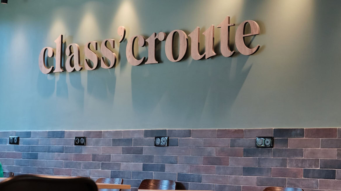 enseigne classcroute en bois sur mur vert carrelé