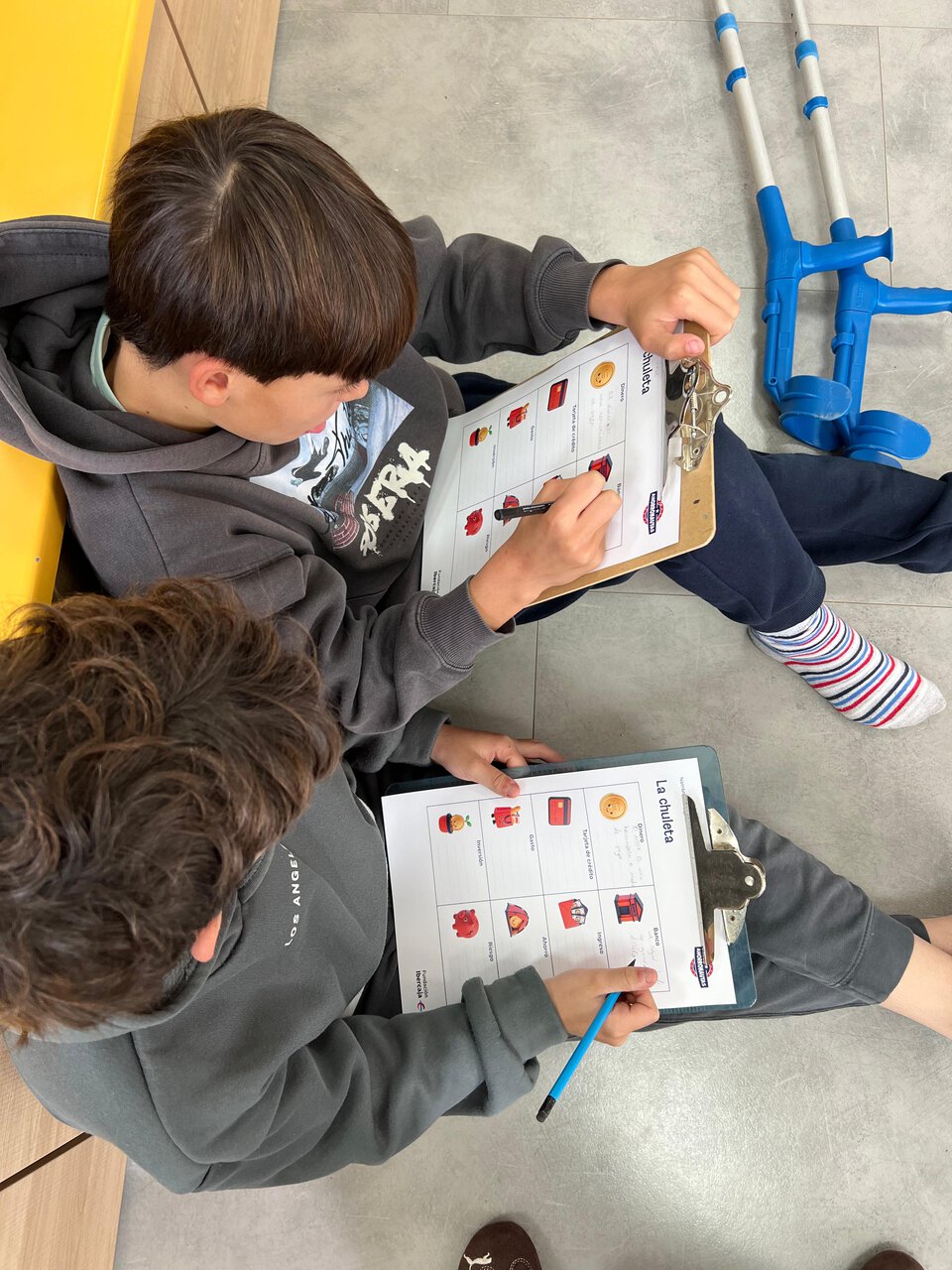 niños trabajando en hojas con portapapeles
