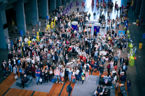 feria familiar en pabellón con stands coloridos